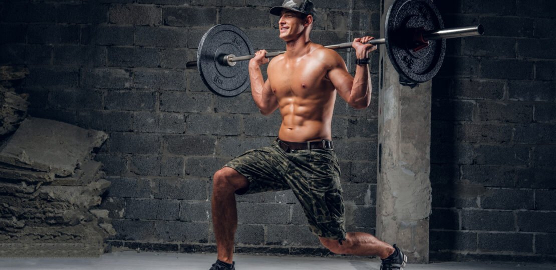 Man is doing exercises with heavy barbell